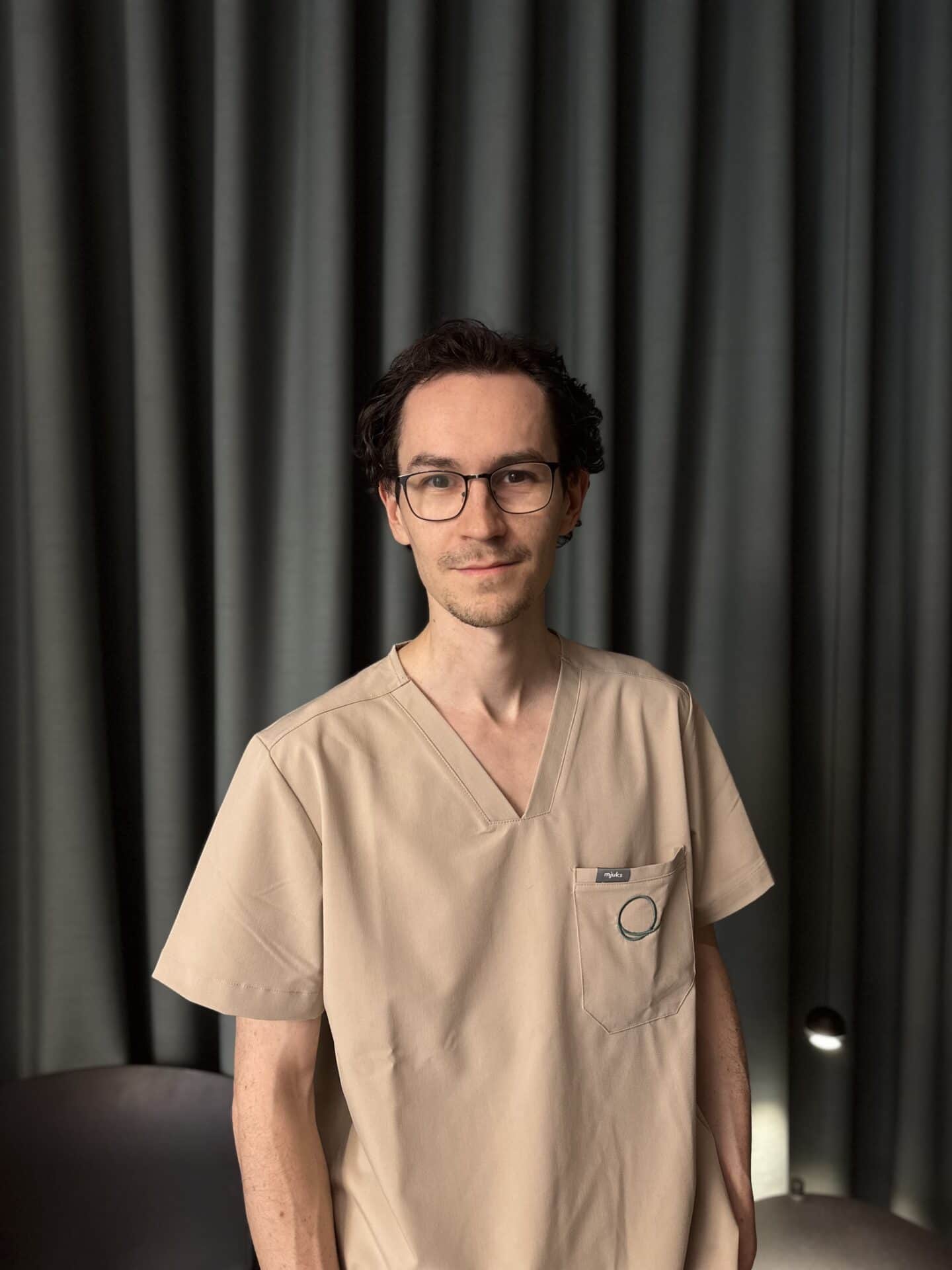 Dr. Andreas Mitterbauer im Einzelporträt vor einem grünen Vorhang