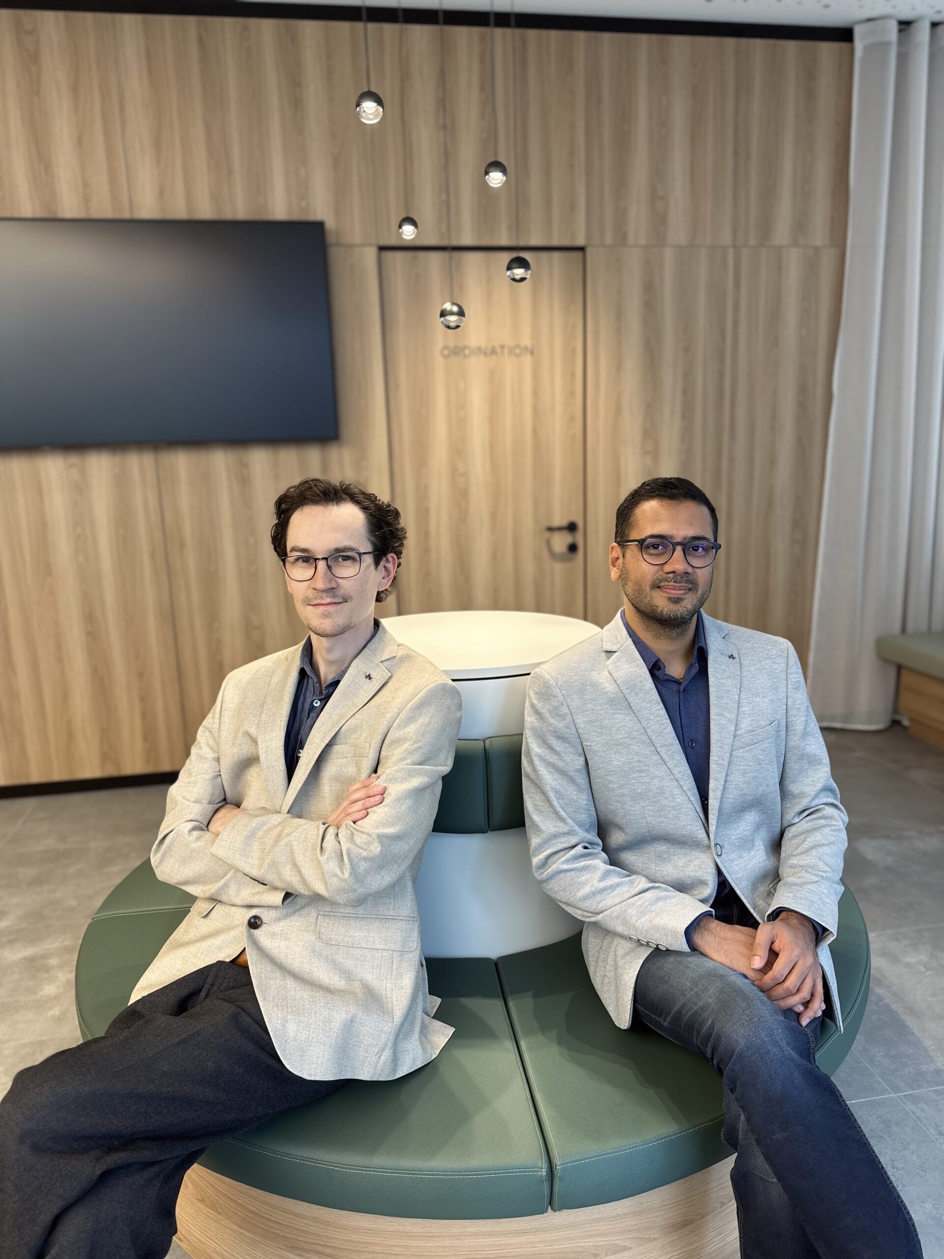 Dr. Mitterbauer und Dr. Bhangu, FACHÄrzte für Allgemeinchirurgie und Viszeralchirurgie sitzend im Empfangsbereich des Endoskopiezentrum Stockerau.